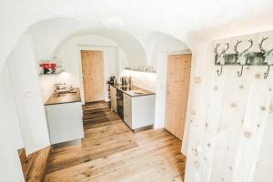施库尔Il Maschun im historischen Engadinerhaus的厨房拥有白色的墙壁、木地板和柜台。