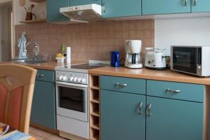 普劳恩Vorbeischauen in Plauen 2的厨房配有蓝色橱柜和炉灶烤箱。