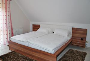克桑滕克桑滕伯格博里克公寓的一张带木制框架和白色床单的床