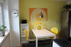 代特莫尔德Ferienwohnung am Stemberg的厨房配有白色的桌子和黄色的椅子