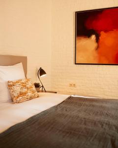巴尔洛Het Knechthuys的卧室配有一张床,墙上挂有绘画作品