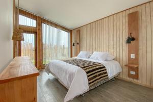 纳塔列斯港AKA Patagonia的一间卧室设有一张大床和一个大窗户