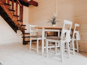 科尔别卢夫Eko Domek w górach的一张木桌,四周摆放着四把白色椅子