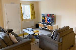纽马基特13 The Grosvenor, luxury flat, central Newmarket,的客厅配有2张沙发和1台平面电视