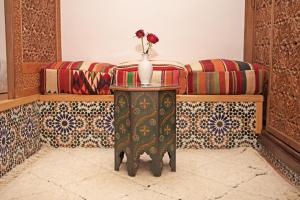 马拉喀什Riad Daria Suites & Spa的花瓶,桌子上放着花