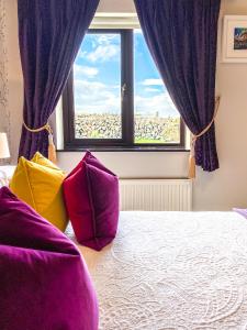杜林Daly's House的一间卧室配有紫色窗帘和一张带色彩缤纷枕头的床