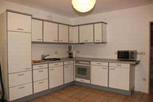 雷姆沙伊德Chrissi und Micha的厨房配有白色橱柜和微波炉