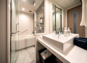 仙台Daiwa Roynet Hotel Sendai Ichibancho PREMIER的白色的浴室设有水槽和淋浴。