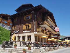 贝特默阿尔卑全景餐厅酒店 的前面设有桌椅的建筑