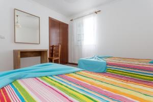 马达莱纳Apartamentos Oliveira的一间卧室配有一张带彩色毯子的床