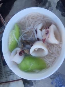 Huxi彩色渔之居民宿的桌上一碗汤,配面条和洋葱