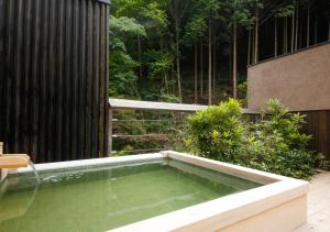 Manno阿讃琴南汤山荘日式旅馆的花园中的一个游泳池