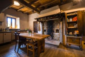 PolinagoOstello Podesteria di Gombola - arte e territorio的厨房配有木桌和石制壁炉。
