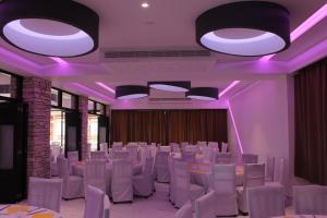 珊瑚湾佩特撒公寓式酒店的一间设有白色桌椅和紫色照明的客房