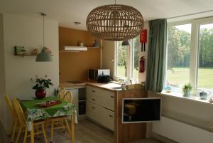 Heeswijk-DintherVakantieboerderij 't Zand - Appartement的厨房配有桌子、电视和桌椅