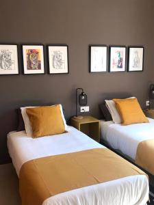 梅里达Apartamentos Élite - Art Collection - Pablo的墙上有两张照片的房间的床铺
