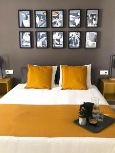 梅里达Apartamentos Élite - Art Collection - Pablo的一间卧室配有一张带黄色枕头的床,墙上挂有图片