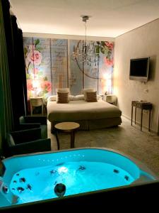 梅里达Hotel Spa Adealba的一间客房内配有床和浴缸的房间
