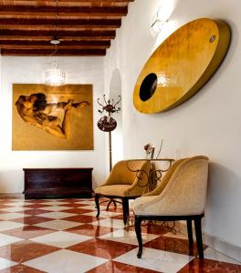 摩德纳La Corte Dei Sogni B&B的客厅配有两把椅子和壁挂式冲浪板
