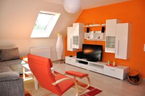马林费尔德Ferienhaus Müritzsonne / OG-Appartement的客厅设有橙色墙壁和电视。