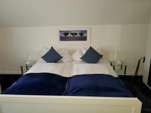 巴特萨尔茨乌夫伦Villa zur schönen Aussicht的一张配有蓝色和白色床单及枕头的大床