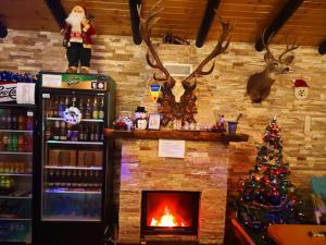 丰达塔Pensiunea Edera的一间带壁炉的房间,一间商店里有一棵圣诞树