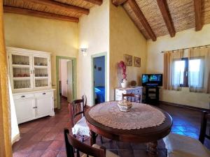 阿比亚多利Villa La Quercia - Capriccioli的一间带桌椅和电视的用餐室