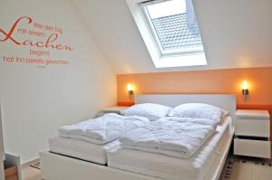 马林费尔德Ferienhaus Müritzbrise / OG-Appartement的卧室配有白色床和天窗
