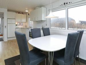 森讷维4 person holiday home in Ringk bing的厨房以及带白色桌椅的用餐室。