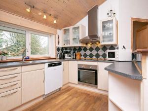 森讷维10 person holiday home in Ringk bing的一间厨房,配有白色家电和木制天花板