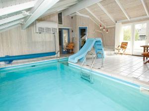 莱斯8 person holiday home in L s的一座房子里一个带滑梯的游泳池