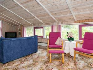 菲耶勒鲁普8 person holiday home in Glesborg的客厅配有紫色椅子和桌子