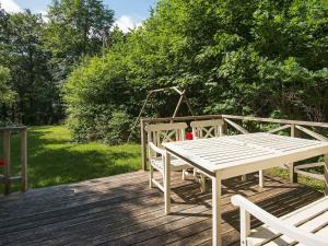 锡尔克堡4 person holiday home in Silkeborg的木制甲板上的白色桌子和椅子