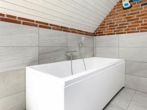 灵克宾12 person holiday home in Ringk bing的砖墙浴室内的白色浴缸