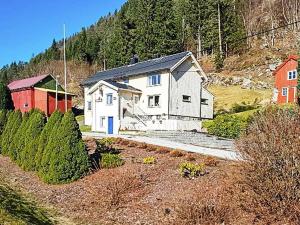 EidsvågHoliday home EIDSVÅG III的山丘上一座白色房子,有红色谷仓