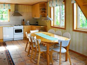 卢恩斯基尔Four-Bedroom Holiday home in S-Uddvalla的厨房配有木桌和白色家电