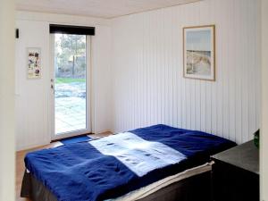 克兰尼茨8 person holiday home in R dby的一间卧室设有蓝色的床和窗户。