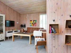 厄斯泰兹6 person holiday home in rsted的客厅设有木墙和木桌