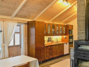 FreiHoliday Home Rensvikholmen的厨房配有木制橱柜、水槽和炉灶。