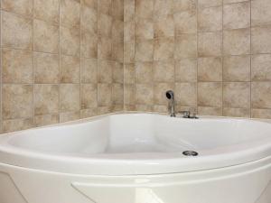 Bunken8 person holiday home in lb k的瓷砖浴室设有白色浴缸。