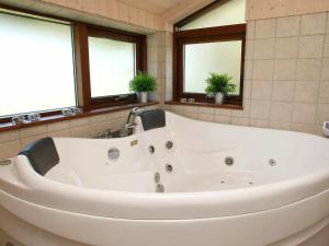 图鲁普斯特兰德8 person holiday home in Fjerritslev的带窗户的浴室内的白色浴缸