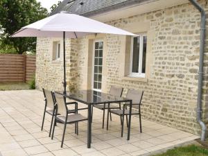 弗莱斯维尔布兰格力2号度假屋的庭院里配有桌椅和遮阳伞