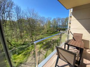 科沃布热格迪优内度假公寓的阳台设有长凳,享有树林美景。