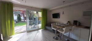 波别罗沃Apartament 7的一间带桌子的客厅和一间带绿色窗帘的厨房
