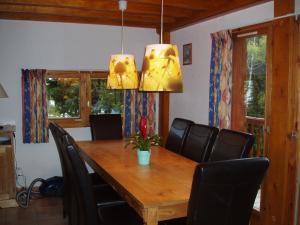 OzMountain Chalet in Oz en Oisans with Lovely Views over Lake的用餐室配有木桌和黑椅子