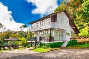 昆达桑Sutera Sanctuary Lodges At Kinabalu Park的旁边设有围栏的白色房子