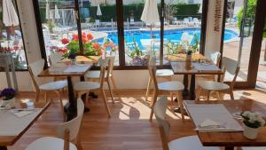 罗列特海岸Hotel Mireia的一间带桌椅的餐厅和一个游泳池