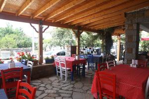 格克切达镇Yeni Bademli Konuk Evi的一间设有红色桌椅和木屋顶的餐厅