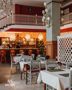 库巴Macara Village Resort的一间带桌椅的餐厅和一间酒吧