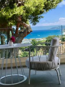 特罗佩阿S'O Suites Tropea的一张椅子和一张桌子,享有海景